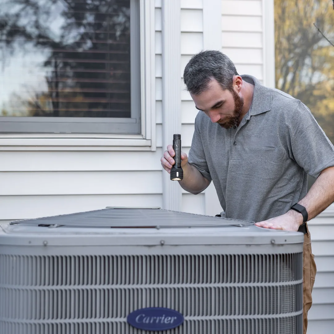 Technician servicing an outdoor HVAC unit